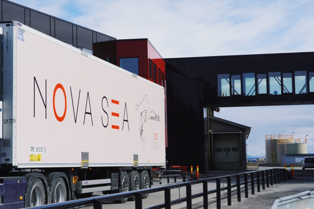 Ein Nova-Sea-Transportfahrzeug vor der modernen Küstenanlage des Unternehmens – Symbol für die Logistik- und Exportaktivitäten norwegischer Lachsprodukte.